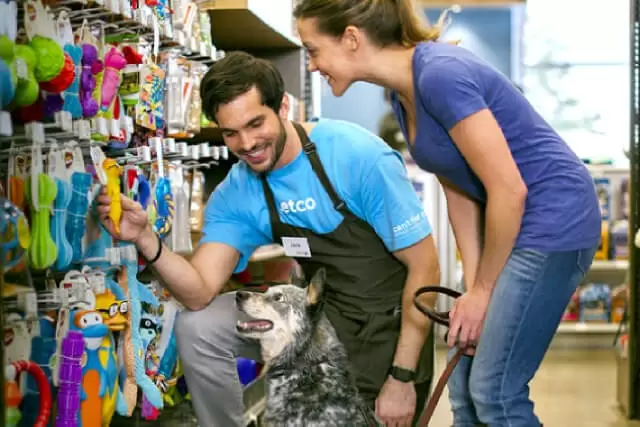 A pet owner carefully choosing a pet accessory in a pet store,