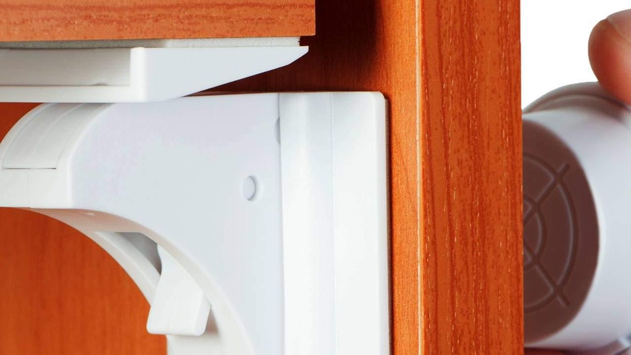 A demonstration of child safety locks installed on kitchen cabinets.