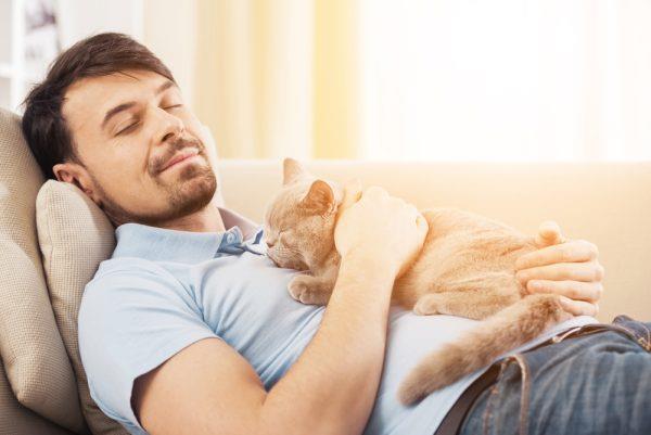 A pet owner happily cuddling their pet